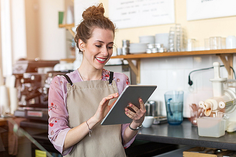 Junge Frau mit digitalem Tablet im Café