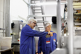 Besprechung mit Kollegen an einer Maschine