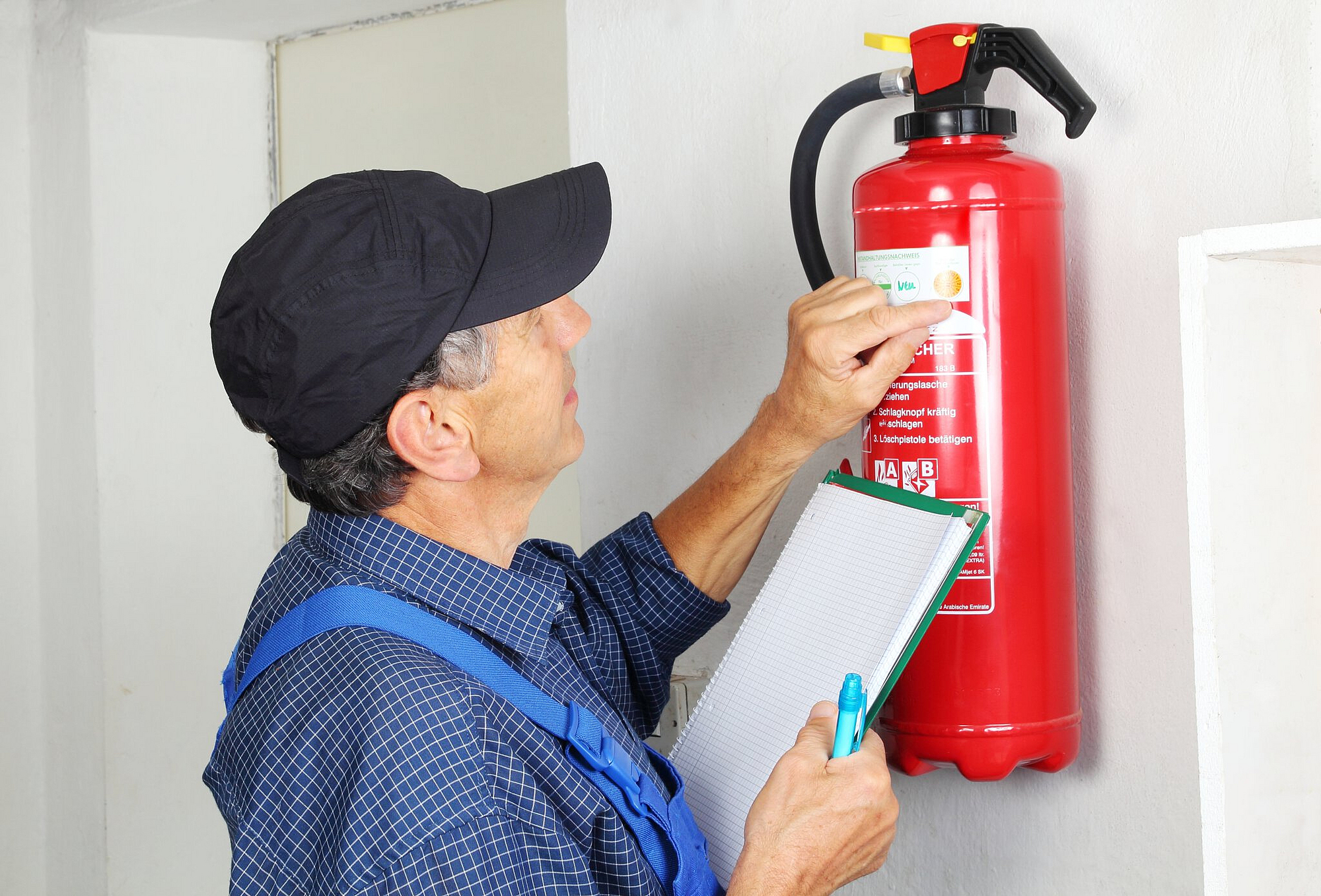 Fachmann bei der Prüfung eines Feuerlöschers