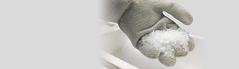 Eine Hand mit Handschuh hält Trockeneispellets