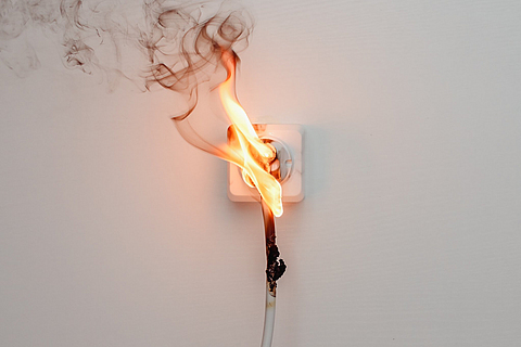 Elektrischer Kurzschluss. Fehler durch brennenden Draht und Rosettensteckdose im Haus