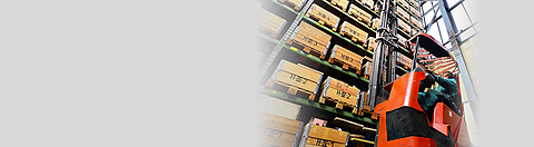 Person arbeitet an einem Hochregallager im Gabelstapler.