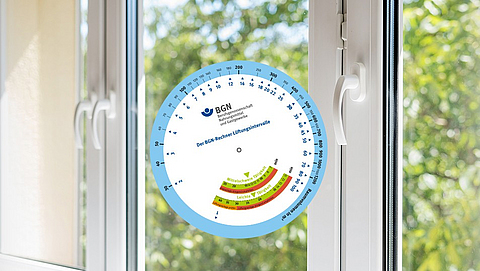 Die BGN Lüftungsscheibe vor einem Fenster.