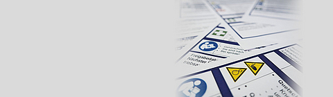 Verschiedene Betriebsanweisungen liegen durcheinander aufeinander.