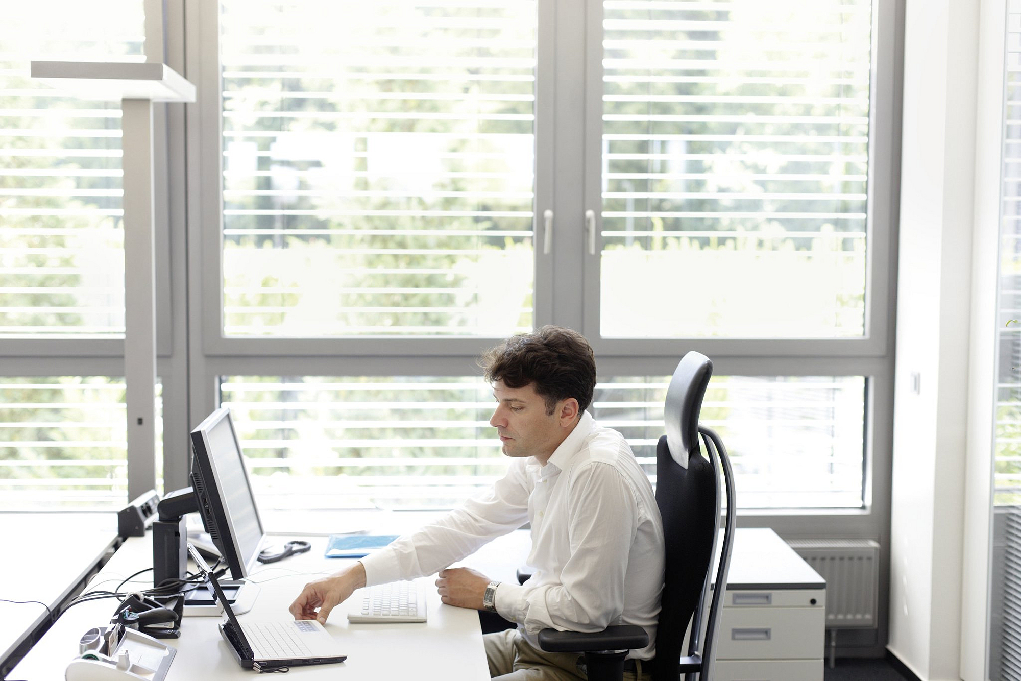 Mann sitzt am Schreibtisch vor dem Computer