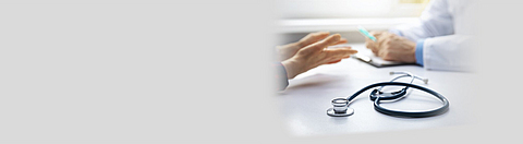 Medizinische Beratung - Arzt im Gespräch mit Patienten in der Arztpraxis. Im Fokus das Stethoskop