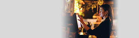 Servicekraft im Restaurant gibt Bestellung im Computer ein.