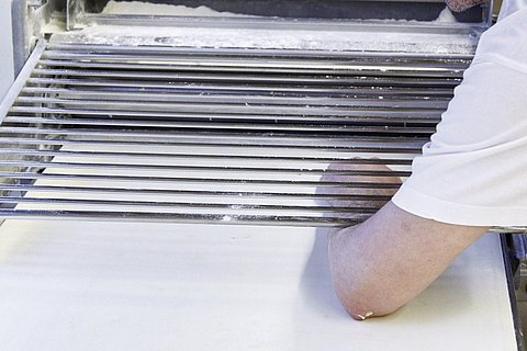 Prüfen, ob die Hand unter dem Gitter der Teigausrollmaschine passt