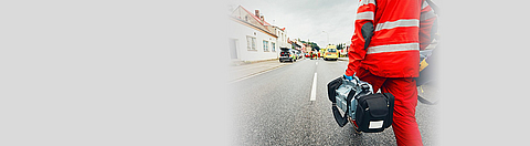 Ein Sanitäter läuft mir Ausrüstung auf einen Unfall zu.