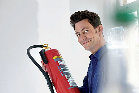 Mann hat einen Feuerlöscher in der Hand