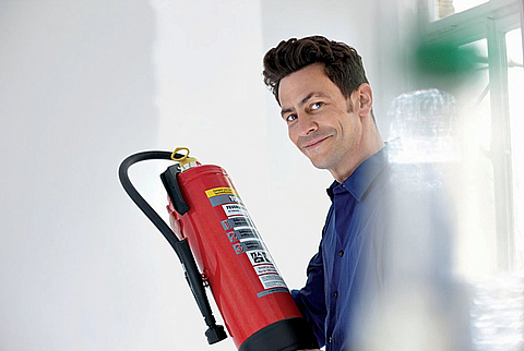 Mann hat einen Feuerlöscher in der Hand