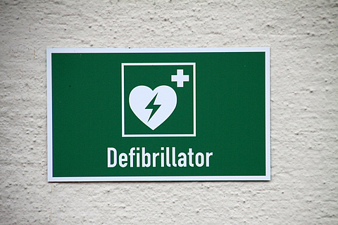 Schild weist auf Defibrillator hin