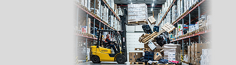 Im Logistikzentrum fallen Waren aus den Regalen auf einen Gabelstapler