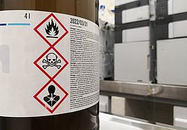 Chemische Substanz in einem Labor. Braunglasflasche. Markiert mit GHS-Symbolen mit Toxizitäts-, Entflammbarkeits- und Todeswarnungen.