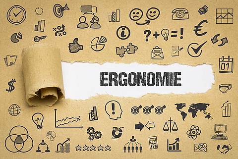Kraftpapier mit Symbolen rund um den Begriff Ergonomie in der Mitte