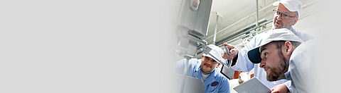 Unterweisung in Fleischerei an der Entschwartungsmaschine, drei Personen