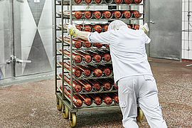 Mann schiebt schweren Räucherwagen  mit eigener Kraft