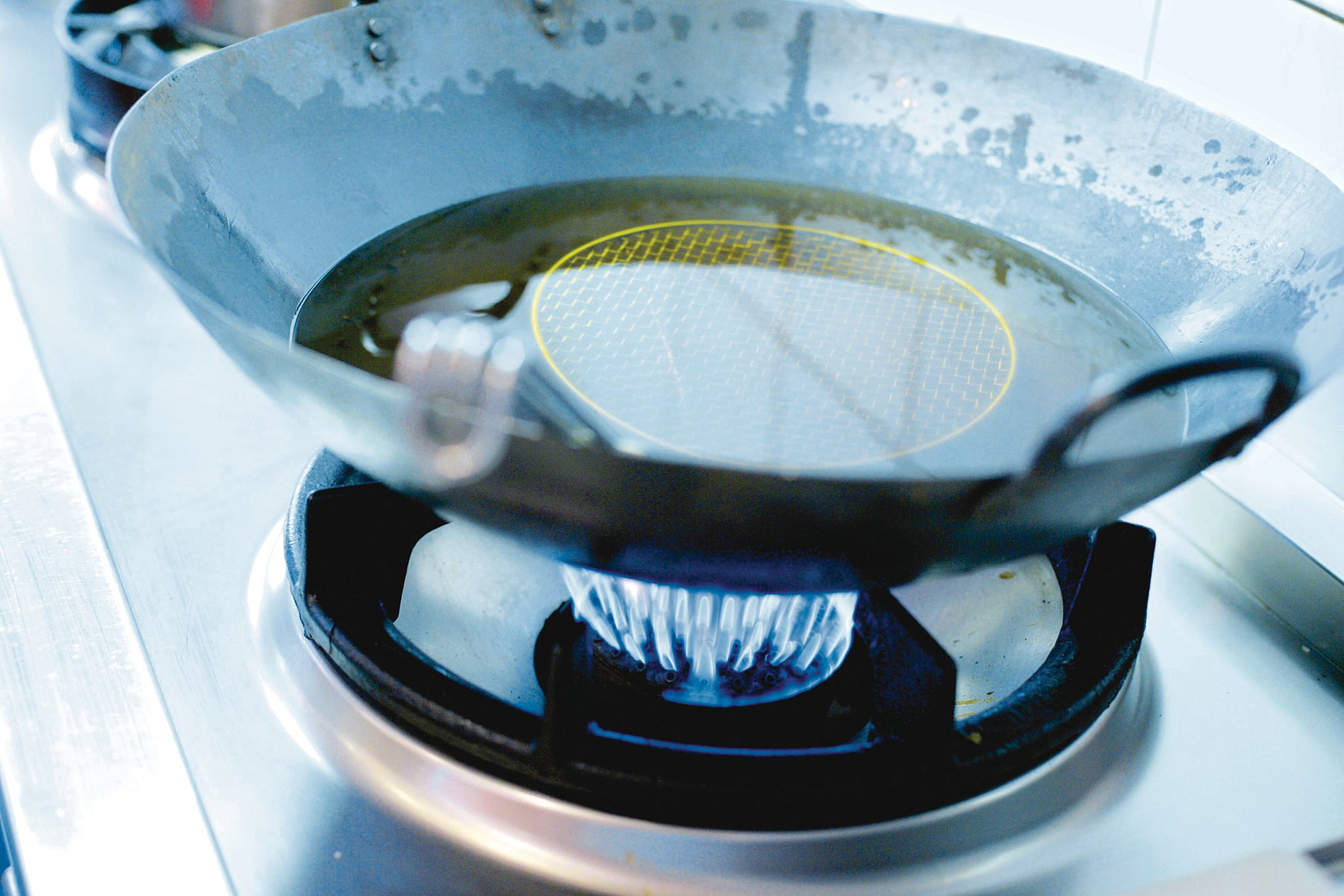 Öl im Wok auf Gasherd erhitzt