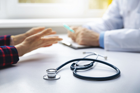 Medizinische Beratung - Arzt im Gespräch mit Patienten in der Arztpraxis. Im Fokus das Stethoskop