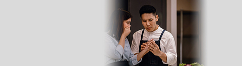 Mitarbeiterin hat sich die Hand verletzt und ein anderer Mitarbeiter schaut sich die Wunde an