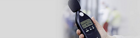 Lärmmessung in Abfüllhalle: Hand hält Lärmmessgerät