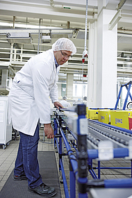 Packstation wird von Mitarbeiter per Handkurbel auf die richtige Höhe eingestellt