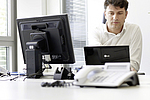 Mann sitzt am Schreibtisch vor dem Computer