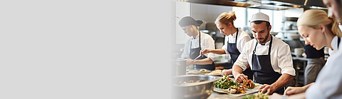 Küchenteam bereitet in der Küche Gerichte zu.